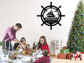 Custom nautical metal sign featuring a ship wheel and sailboat design with personalized name and year, ideal for coastal wall décor