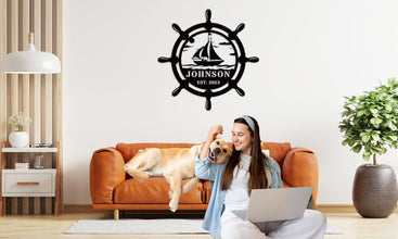 Custom nautical metal sign featuring a ship wheel and sailboat design with personalized name and year, ideal for coastal wall décor