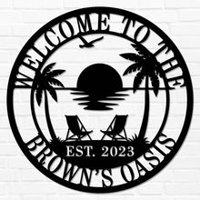 Custom metal wall sign with beach sunset scene, palm trees, and personalized text “Welcome to the Brown’s Oasis Est. 2023” in black powder-coated steel