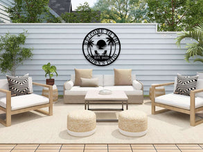 Custom metal wall sign with beach sunset scene, palm trees, and personalized text “Welcome to the Brown’s Oasis Est. 2023” in black powder-coated steel