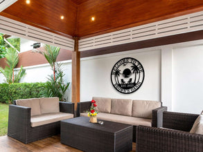 Custom metal wall sign with beach sunset scene, palm trees, and personalized text “Welcome to the Brown’s Oasis Est. 2023” in black powder-coated steel