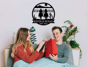 Personalized cowboy couple metal wall art featuring two riders holding hands, custom name and date, rustic western decor, laser-cut steel sign for home or gift