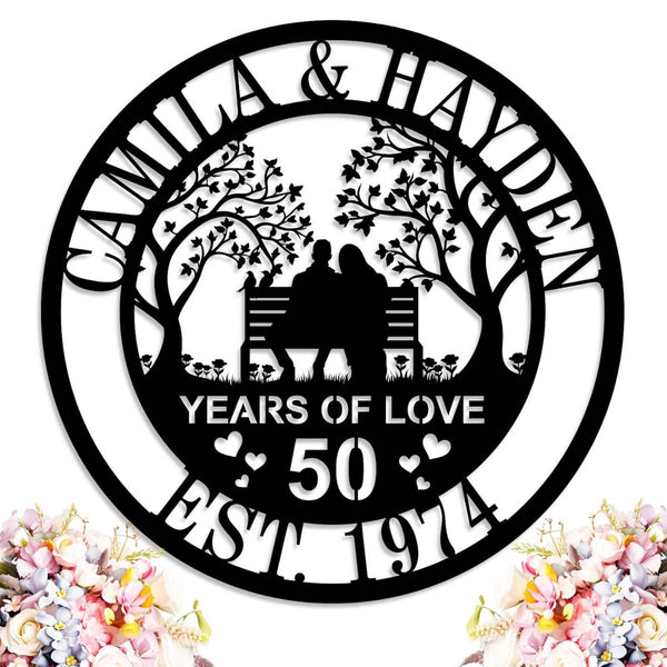 Custom laser-cut steel anniversary sign featuring a couple on a bench with trees, personalized with names, anniversary year, and established date