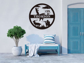 Custom round black metal hunting and fishing sign featuring a fisherman, deer, hunter silhouette, and personalized family name – laser-cut from powder-coated steel for outdoor wall decor.