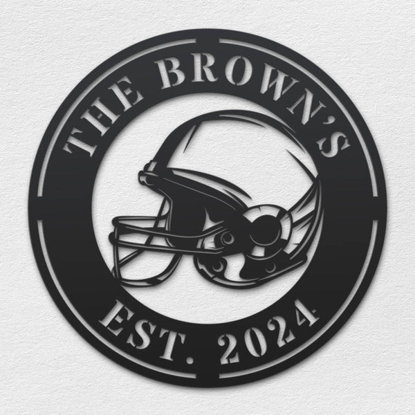 Black metal football helmet sign with personalized text "THE BROWN'S EST. 2024", laser-cut from steel and powder-coated, perfect for sports-themed home decor.