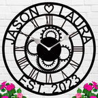 Large personalized black metal wall clock with laser-cut cutout gears, couple names Jason and Laura, center heart icon, established 2023, and Roman numerals.