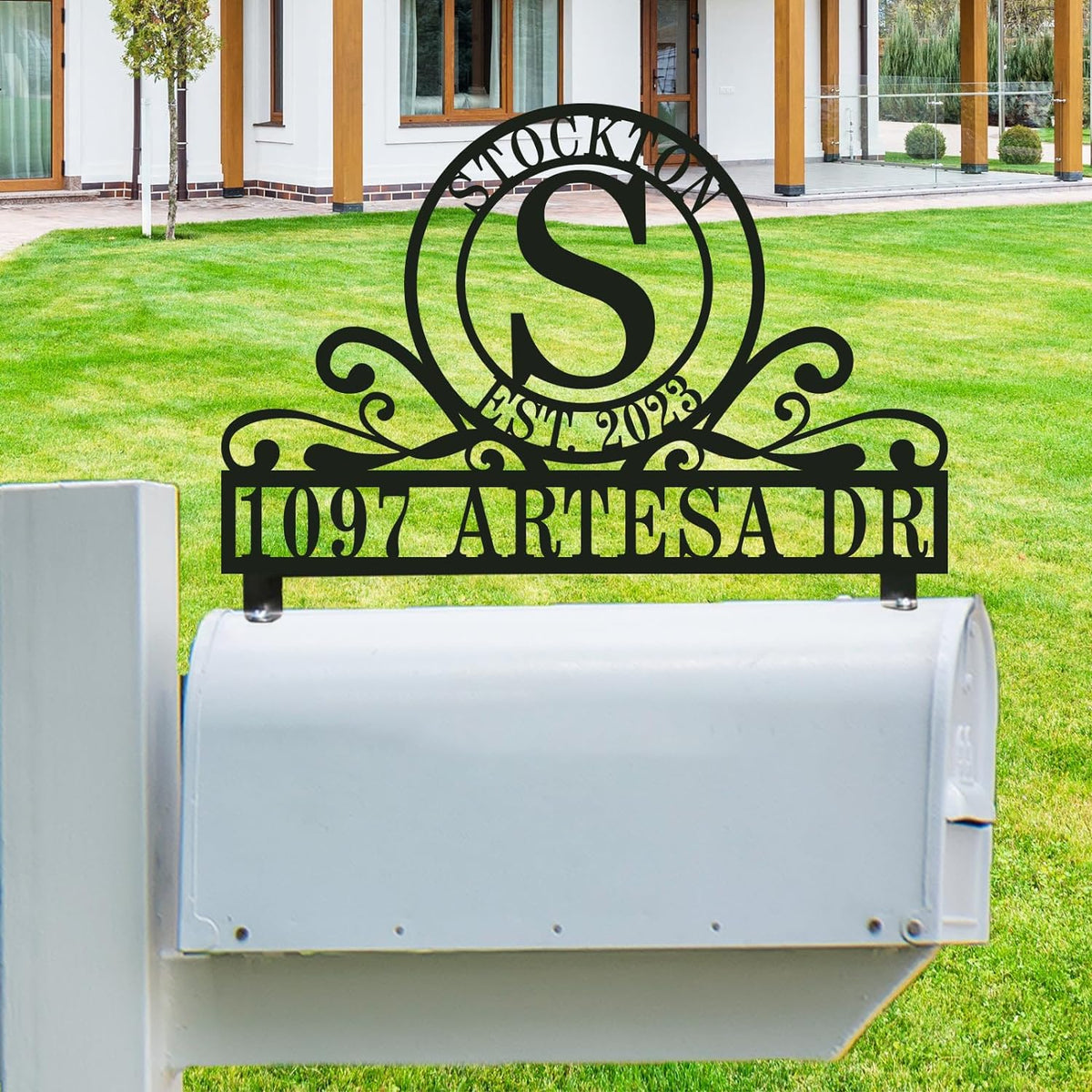 Personalized stainless steel mailbox topper with double-ring monogram, family name, established date, and custom street address in black rust-proof finish.