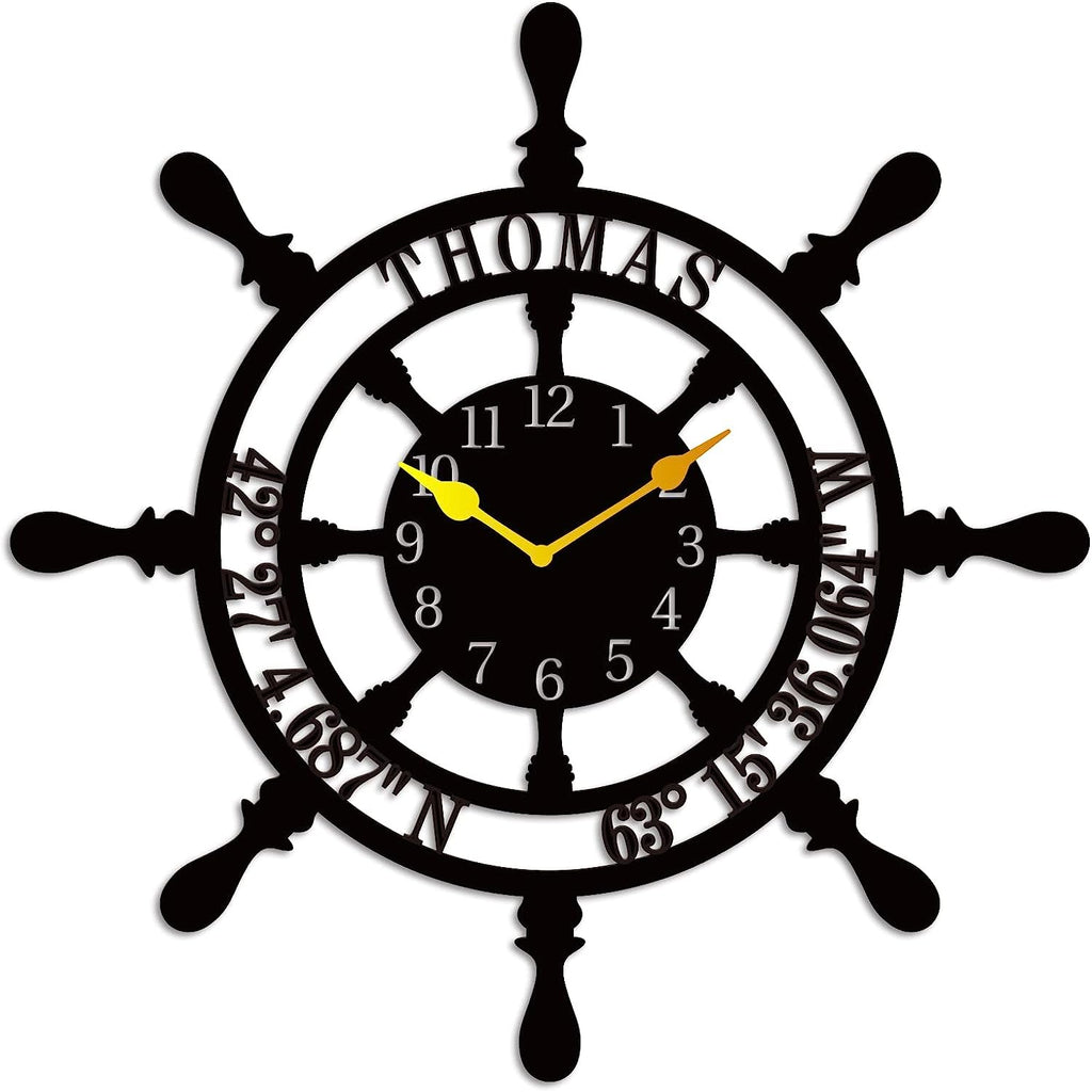 Large personalized black metal wall clock shaped like a ships wheel, featuring laser-cut cutout name Thomas, custom GPS coordinates, and Arabic numbers.