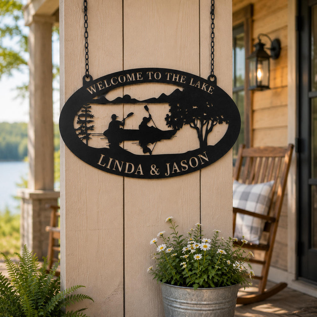 Black powder coated metal lake house sign hanging on a rustic porch post with lake view and outdoor decor
