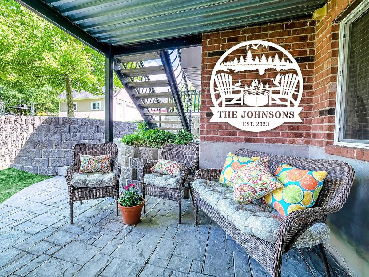 Custom firepit metal sign with family name and established year, laser cut from steel and powder coated, personalized outdoor wall décor with chairs, fire, and nature design.