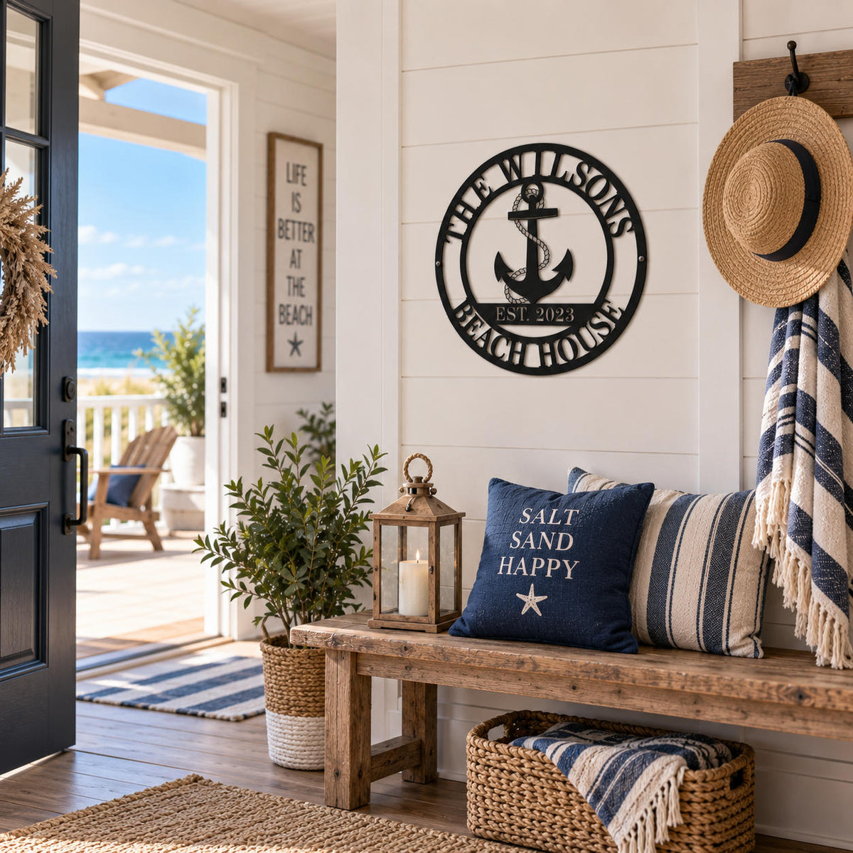 Custom black metal beach house sign with anchor displayed in a bright coastal home entryway.