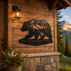 Custom bear family metal sign displayed on the exterior wall of a rustic mountain cabin.
