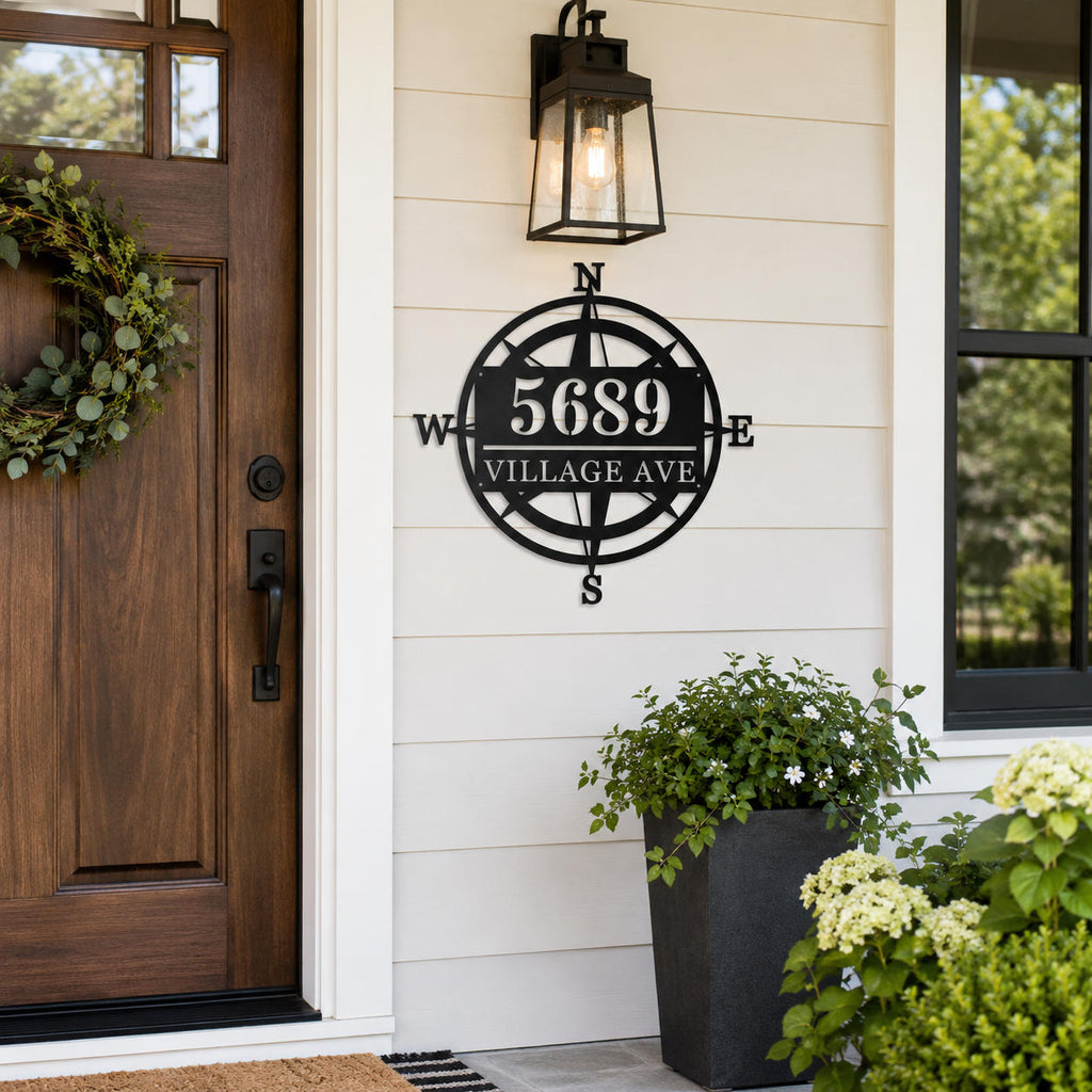 Custom black metal compass address sign displayed beside the front door of an American home.