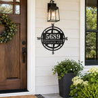 Custom black metal compass address sign displayed beside the front door of an American home.