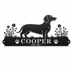 Personalized Dachshund metal name sign featuring Cooper name, paw prints, flowers and established year on a white background.