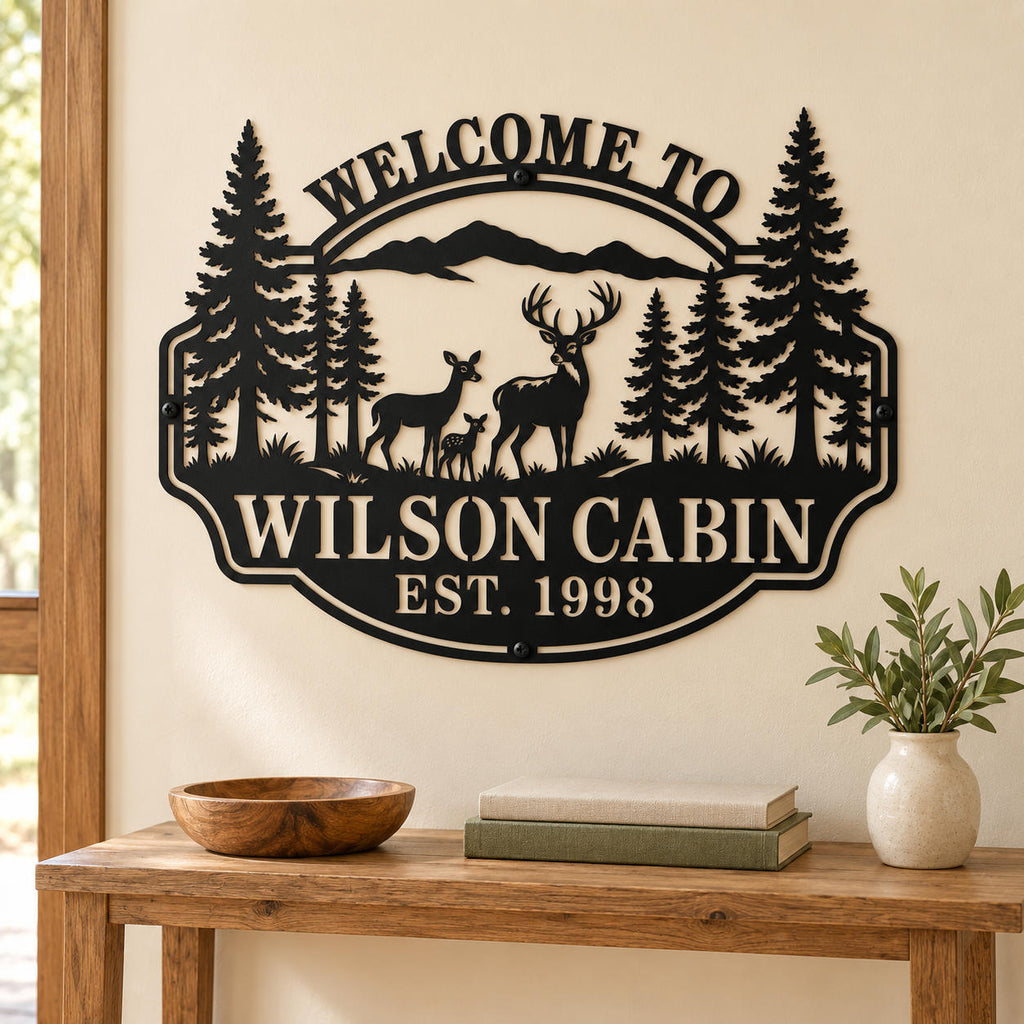 Personalized deer cabin metal sign on a cream wall above a wooden console table with books and a ceramic vase.