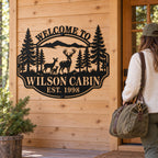 Wilson Cabin metal welcome sign beside a wooden cabin door as a guest arrives carrying a weekend bag.