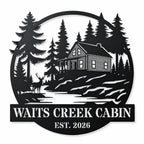 Personalized black metal cabin sign featuring a log cabin, pine trees, deer and custom family name.