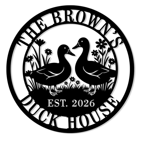 Round black laser-cut steel duck house sign featuring two ducks facing each other with wildflowers and grass, personalized with family name The Browns, Duck House, and EST 2026 — custom farm metal wall art for duck coops and backyard homes