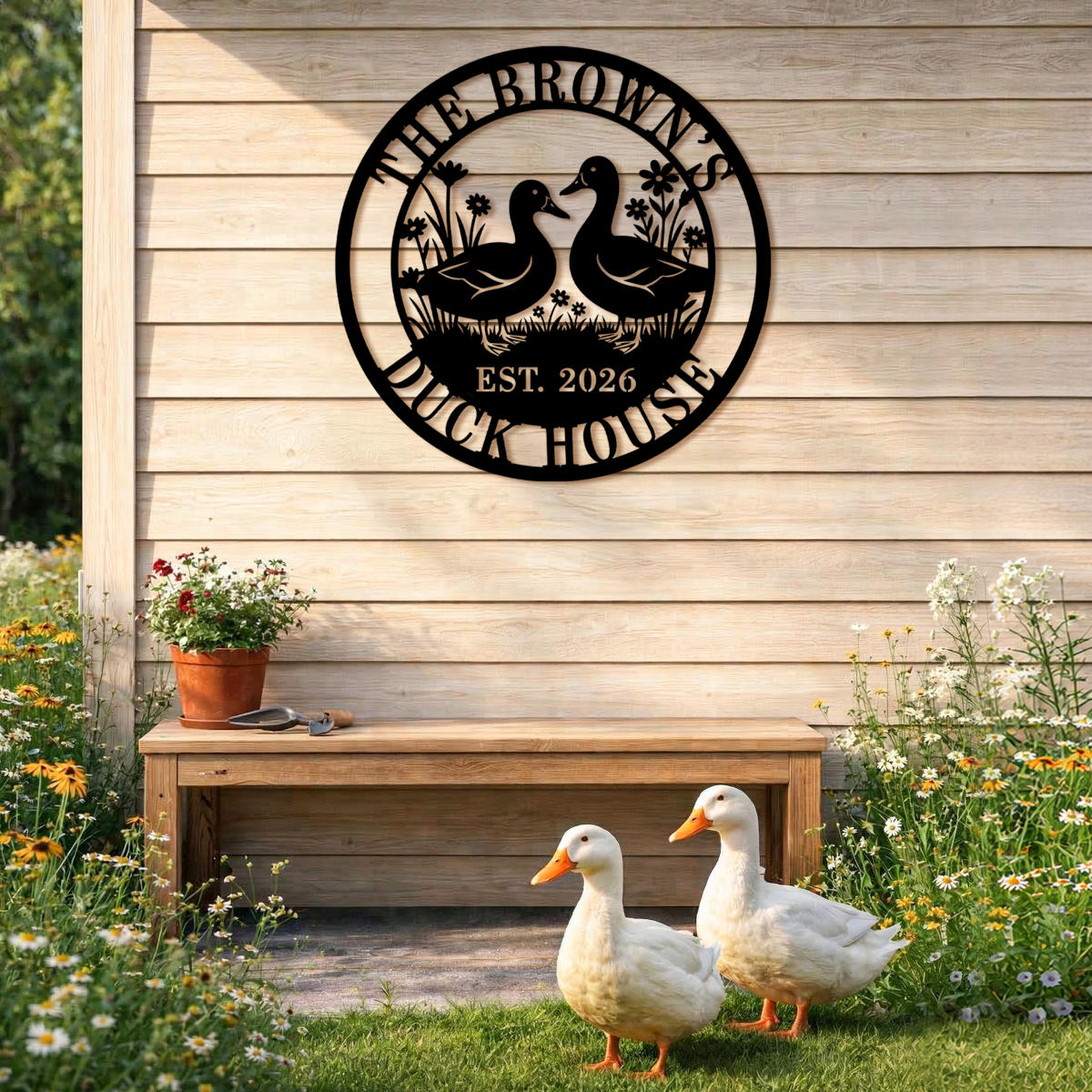 Round black laser-cut steel duck house sign featuring two ducks facing each other with wildflowers and grass, personalized with family name The Browns, Duck House, and EST 2026 — custom farm metal wall art for duck coops and backyard homes