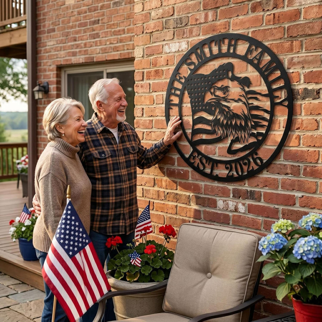 A matte black laser-cut circular metal art monogram, made of heavy-duty 14-gauge steel, featuring a majestic bald eagle profile and waving American flag. The top arc reads "THE SMITH FAMILY" and the bottom arc reads "EST. 2026", both cut-out text. This is an example of a customizable family name sign.