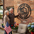 A matte black laser-cut circular metal art monogram, made of heavy-duty 14-gauge steel, featuring a majestic bald eagle profile and waving American flag. The top arc reads "THE SMITH FAMILY" and the bottom arc reads "EST. 2026", both cut-out text. This is an example of a customizable family name sign.