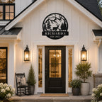 Custom deer mountain metal family name sign displayed above the entrance of a modern farmhouse.