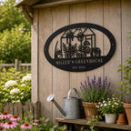 Custom black metal greenhouse sign displayed on a rustic garden shed wall with flowers, plants, and a watering can.