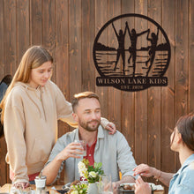 Custom lake kids metal sign featuring children silhouette design, personalized family name and year, round steel wall decor for lake house or cabin