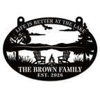 Black laser-cut steel oval lake sign reading "Life is Better at the Lake" with soaring eagle, lake scene, Adirondack chairs, campfire, and pine trees, personalized with "The Brown Family" and EST 2026 — custom lake house metal wall art