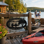 Custom black metal lake sign hanging on a wooden dock fence beside a peaceful lake with kayak and cabin view