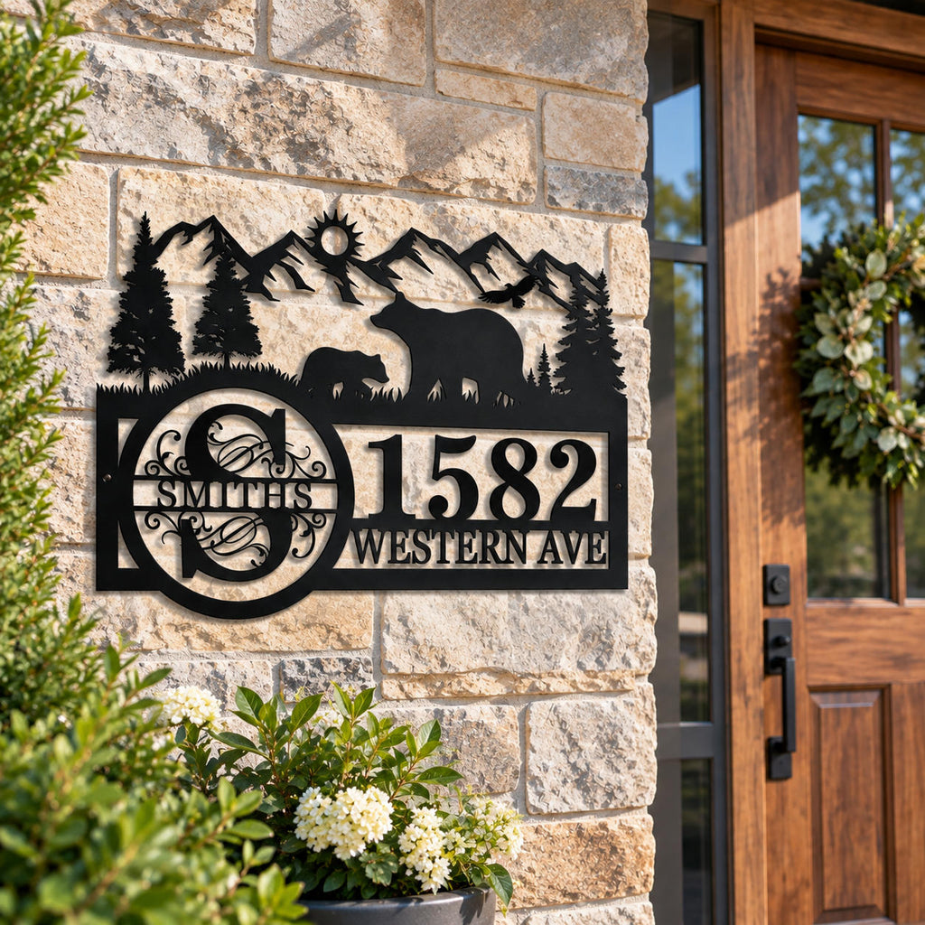 Personalized bear and mountain metal address sign mounted beside the entrance of a rustic American home.