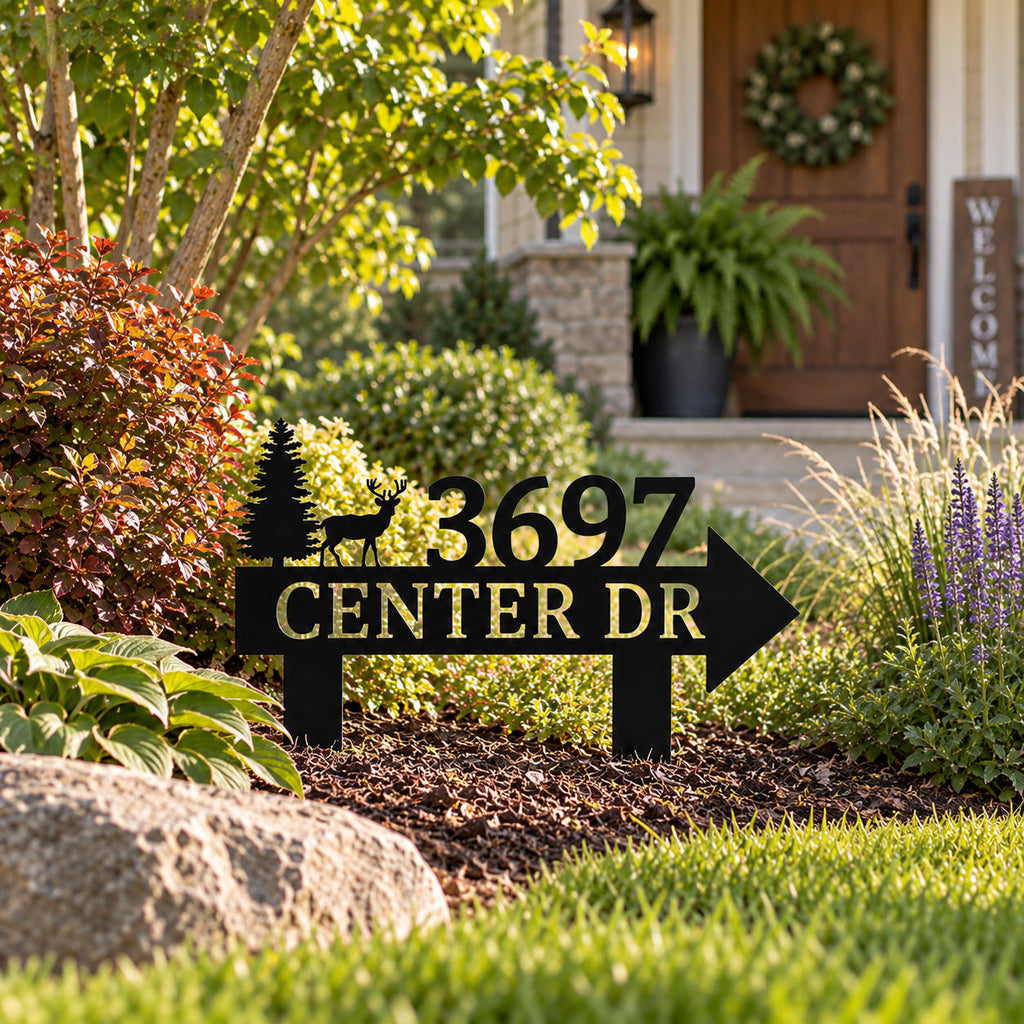 Custom black metal address yard sign with deer and pine tree design displayed near a welcoming home entrance.