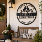 Custom round metal anniversary sign with two lovebirds on branches, personalized with names, years together, and established date.