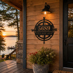 Custom metal compass address sign mounted on a rustic American lake house at sunset.