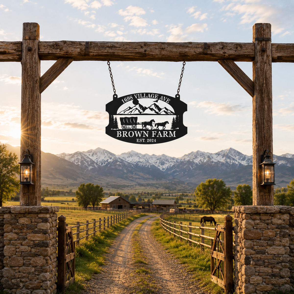 Personalized metal farm sign hanging with chains at a rustic ranch entrance surrounded by mountains and countryside.