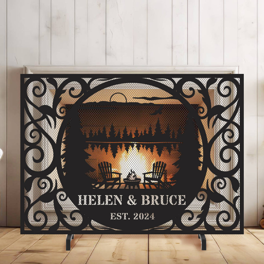 Custom laser-cut metal fireplace screen with personalized family name and lakehouse cabin design in front of a burning fireplace.