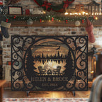 Custom laser-cut metal fireplace screen with personalized family name and lakehouse cabin design in front of a burning fireplace.