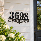 Decorative custom metal house number sign displayed on a bright farmhouse-style front entryway.