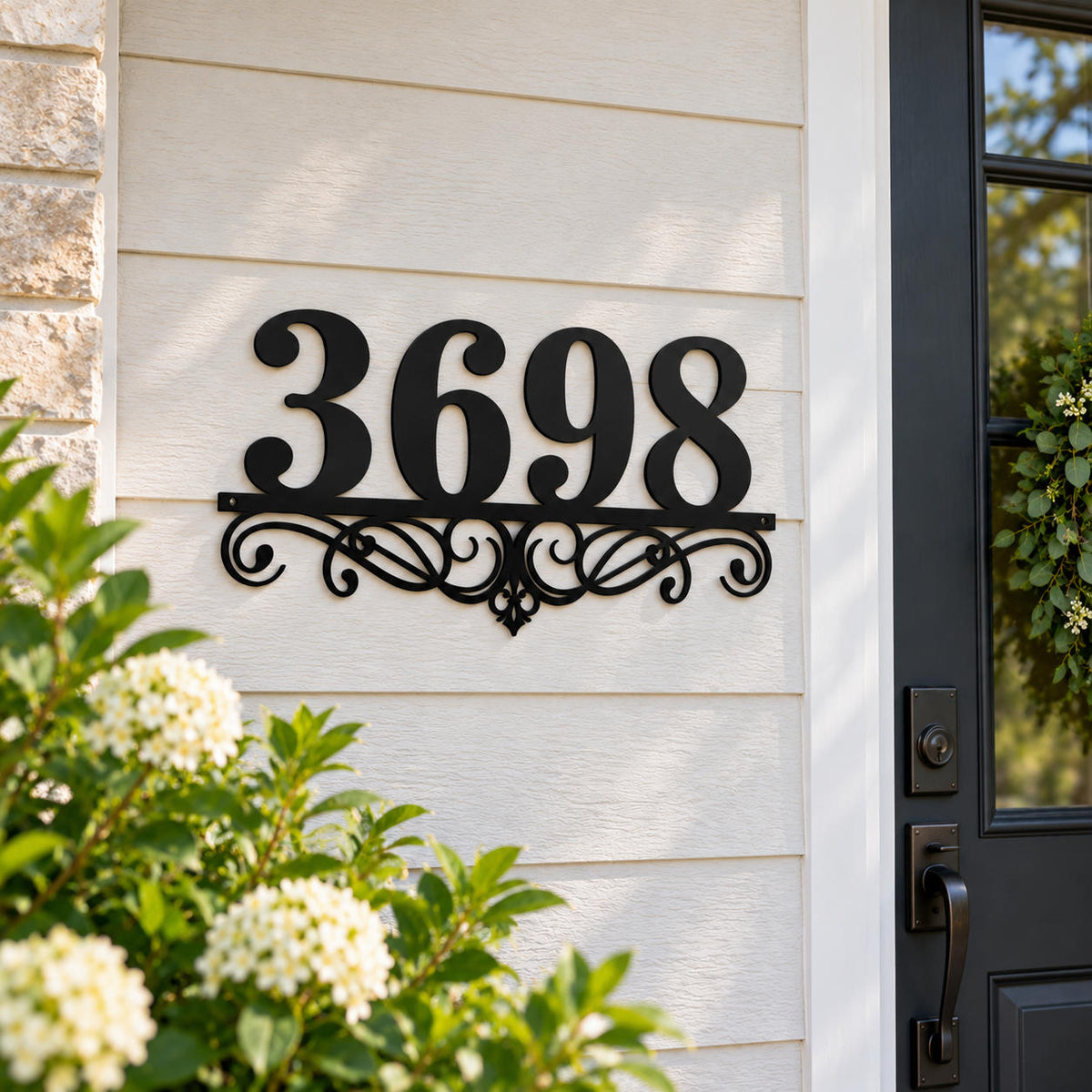 Decorative custom metal house number sign displayed on a bright farmhouse-style front entryway.
