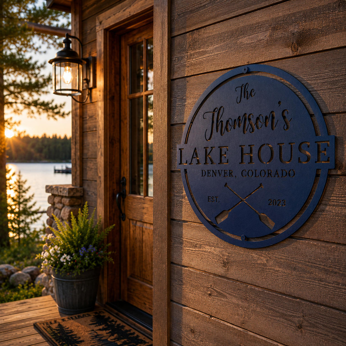 Custom metal lake house sign mounted on a rustic lakeside cabin with family name and crossed paddle design.