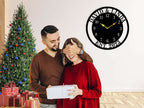 Large personalized black metal wall clock with a solid center dial, featuring laser-cut cutout family names, established 2023, and modern Arabic numbers.
