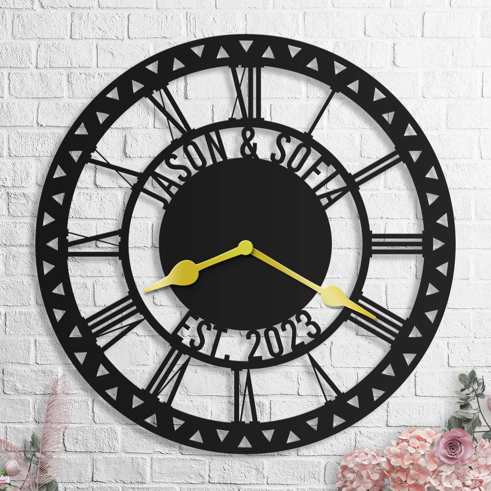 Large personalized black metal wall clock with geometric triangle border, featuring laser-cut cutout family names, established year, and optional numeric styles.