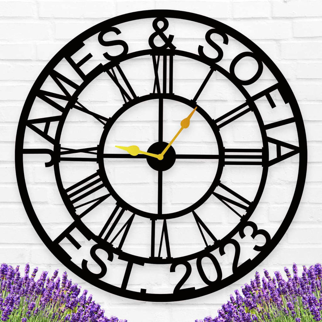 Large personalized black metal wall clock with custom names James and Sofia established 2023, featuring Roman numerals and gold hands for indoor home decor.