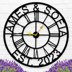Large personalized black metal wall clock with custom names James and Sofia established 2023, featuring Roman numerals and gold hands for indoor home decor.
