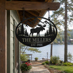 Custom moose family metal sign hanging from a rustic lake house porch overlooking the water.