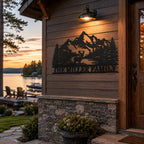 Personalized mountain landscape metal sign installed on lakeside cabin exterior wall.