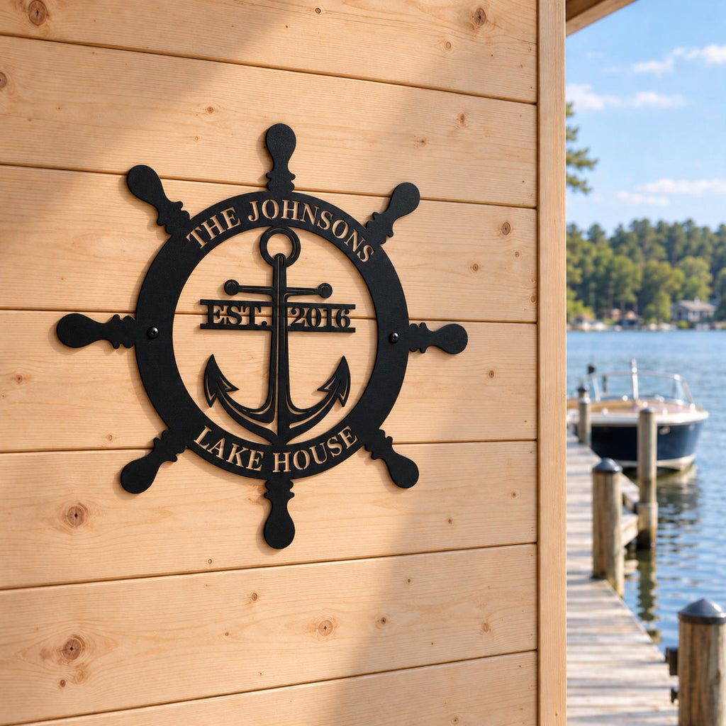 Personalized ship wheel and anchor metal sign on a cedar boathouse wall beside a lakeside dock and moored boat.