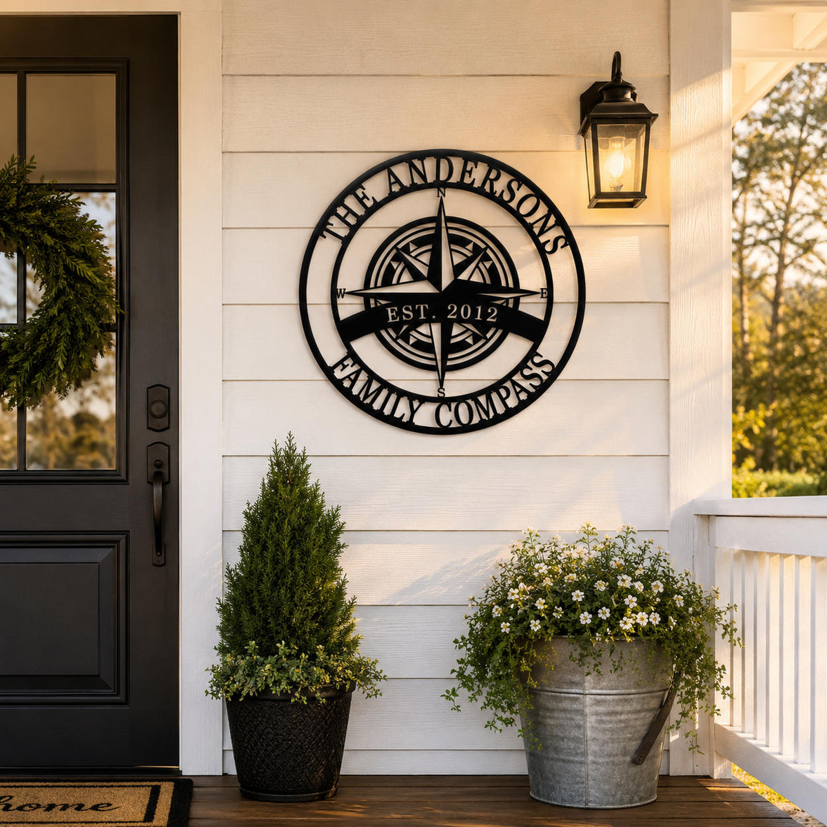 Custom compass metal wall sign with family name displayed on modern farmhouse porch exterior