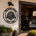 Large personalized compass metal sign mounted on garage exterior wall of a country home